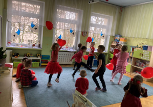Dzieci tańczą z balonami w kształcie serc