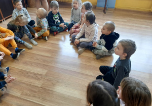 Dzieci siedzą w kręgu na podłodze