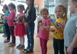 Dzieci stoją z instrumentami i słuchają instrukcji
