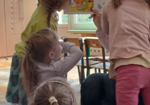 Dziewczynki przyglądają się ilustracjom w ksiażce