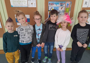 Grupa dzieci w kolorowych perukach i szalonych fryzurach pozuje do zdjęcia