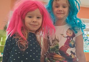 Dziewczynki w kolorowych perukach pozują do zdjęcia