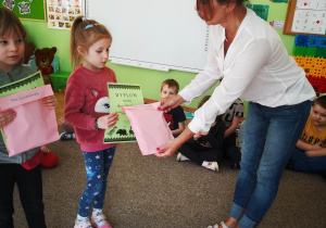 Nauczycielka wręcza dziecku nagrodę i dyplom