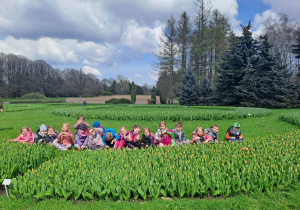 Grupa dzieci pozuje do zdjęcia w tulipanach