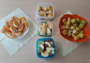 Owoce w miskach i pojemnikach stoją na stole
