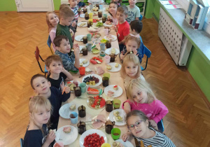 Dzieci samodzielne szykują śniadanie z produktów ustawionych na stole