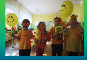 Dzieci pozuja do zdjęcia z rekwizytami do fotobudki oraz balonami.