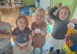Dzieci pokazują do zdjęcia medale otrzymane z okazji Dnia Jeża