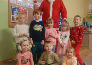 Grupa dzieci pozuje do zdjęcia ze Świętym Mikołajem