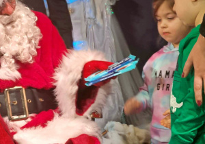 Mikołaj wręcza dzieciom czekolady