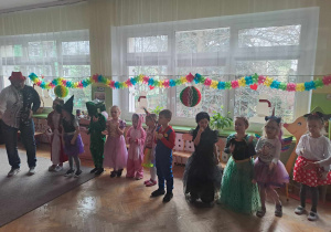 Dzieci w przebraniach tańczą na balu karnawałowym