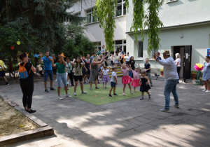 Dzieci i rodzice biorą udział w zabawach tanecznych