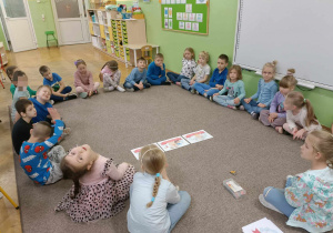 Dzieci siedzą w kole i rozmawiają o prawach dziecka.