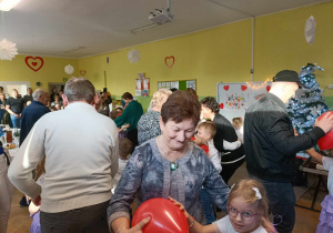 Dziadkowie wraz z wnukami podczas tańca z balonami.