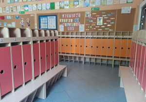 Szatnia przedszkola - kolorowe szafki, tablice korkowe z dekoracjami, dyplomy i certyfikaty